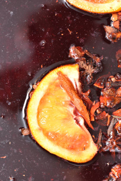 Preparation of mulled wine in a saucepan. In the mulled wine float spices and orange