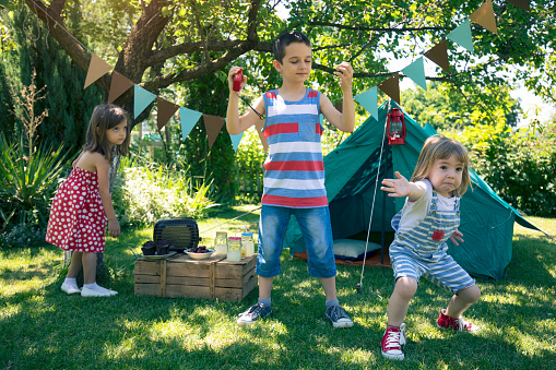 Three little friends having backyard party. Dancing and having fun.