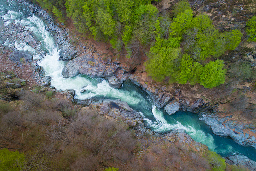 Mountain river flowing in a canyon, bird view, perspective from above, aerial drone shot.