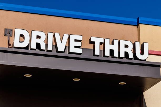 istock White and Blue Drive Thru sign set against a blue sky I 951735244