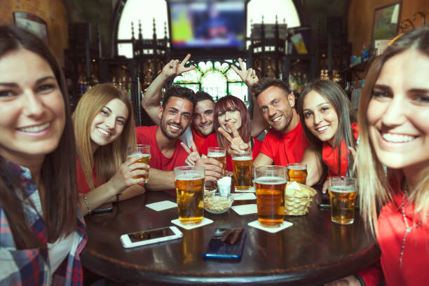 gruppo di persone che festeggiano in un pub bevendo birra - irish culture beer drinking pub foto e immagini stock