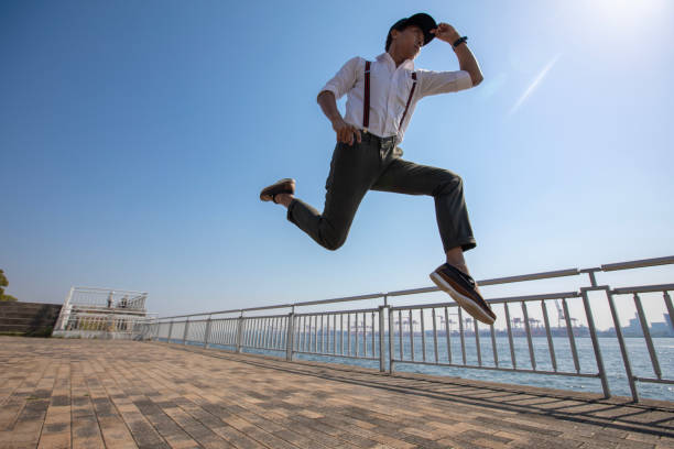 istock Young Asian guy jumping to the sky 951737864