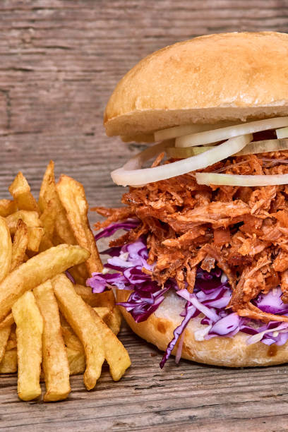 istock Barbeque Pulled pork Sandwich with BBQ Sauce,salad with red cabbageonion,Sauce and Fries on wooden background,Fast food 951742304