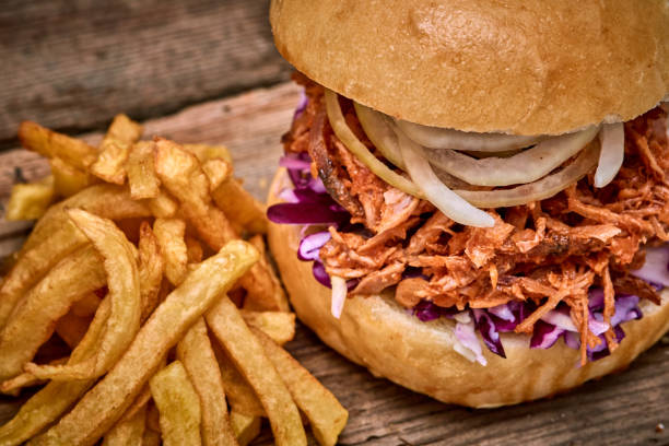 istock Barbeque Pulled pork Sandwich with BBQ Sauce,salad with red cabbageonion,Sauce and Fries on wooden background,Fast food 951745852