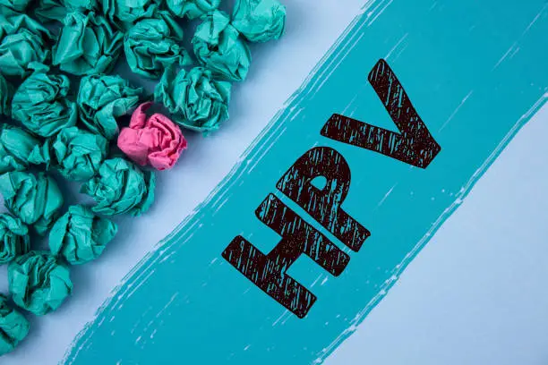 Photo of Writing note showing  Hpv. Business photo showcasing Human Papillomavirus Infection Sexually Transmitted Disease Illness written on Painted background Crumpled Paper Balls next to it.