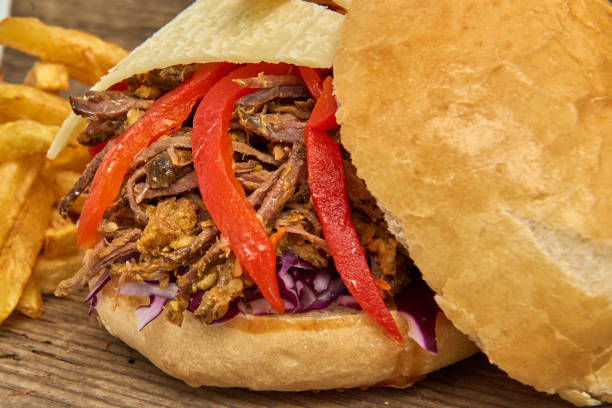 istock Fast food,Barbeque Pulled beff Sandwich with cheese,baked peppers,curry lentils and salad with red cabbage,Sauce and Fries on wooden background 951746874