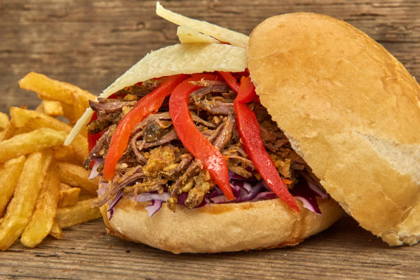 istock Fast food,Barbeque Pulled beff Sandwich with cheese,baked peppers,curry lentils and salad with red cabbage,Sauce and Fries on wooden background 951747018