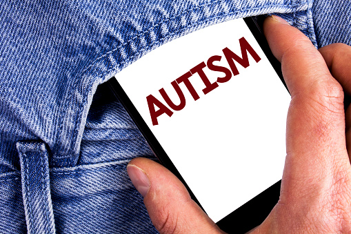 Writing note showing  Autism. Business photo showcasing Autism Awareness conducted by social committee around the globe written Mobile phone screen holding by man the Jeans background.