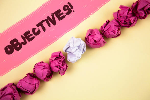 istock Handwriting text writing Objectives Motivational Call. Concept meaning Goals planned to be achieved Desired targets written on Painted background Crumpled Paper Balls Line next to it. 951760696