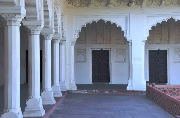 Ornate doors and white columns inside the Agra Fort in India