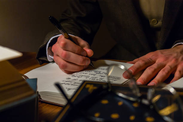 Man writing a letter in a journal at a university stock photo