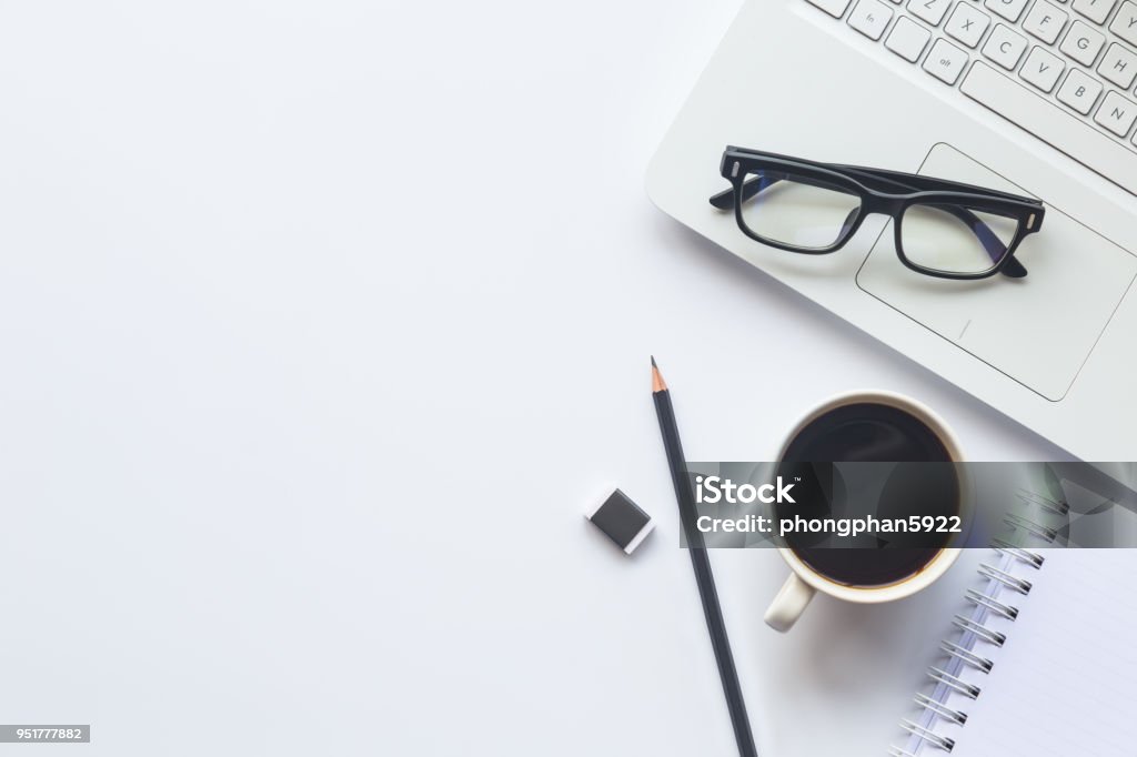 White desk office with laptop, smartphone and other supplies with cup of coffee. Top view with copy space for input the text. Designer workspace on desk top, view with essential elements on flat lay. Desk Stock Photo