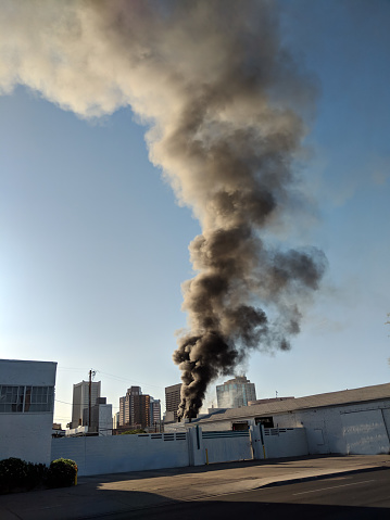 Heavy black smoke plumes from  a warehouse fire in city of Phoenix downtown, Arizona