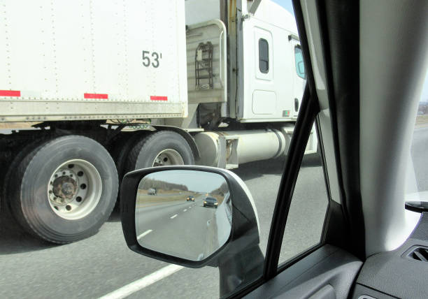Transportation, "Passing a Semi; Rear View Mirror" Transportation...Here we are looking out of the driver side window in a car, as a huge semi, tractor trailer truck, roars past on the left side. semi truck audio stock pictures, royalty-free photos & images