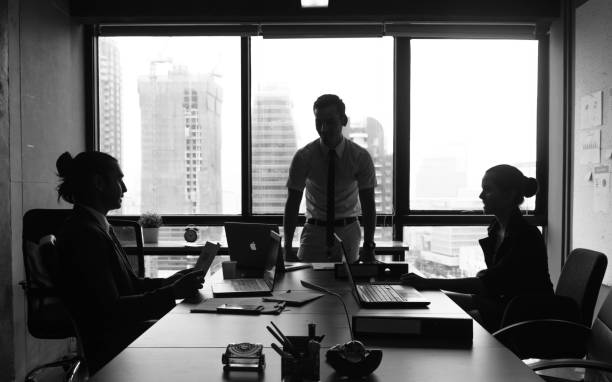 Business people meeting in conference room near window, black and white tone stock photo