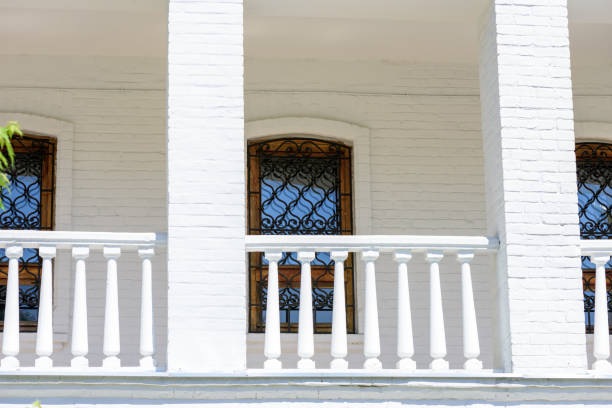 The facade of a brick building with a balcony on a sunny spring day