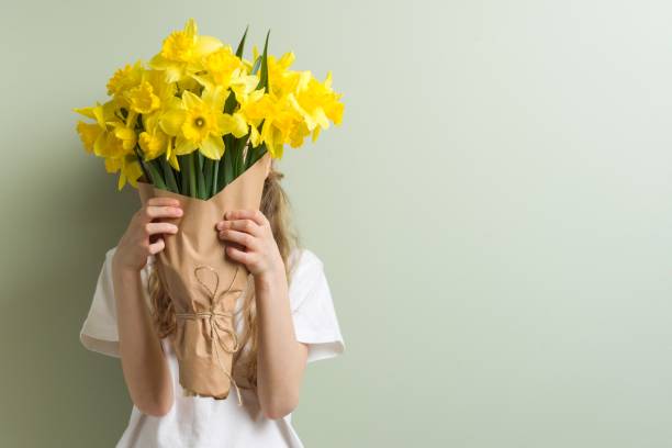 Child girl holding bouquet of yellow flowers. stock photo