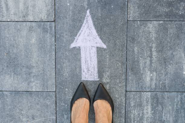 istock Feet and arrow on road. 951824174