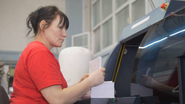 Female worker working with the printing press