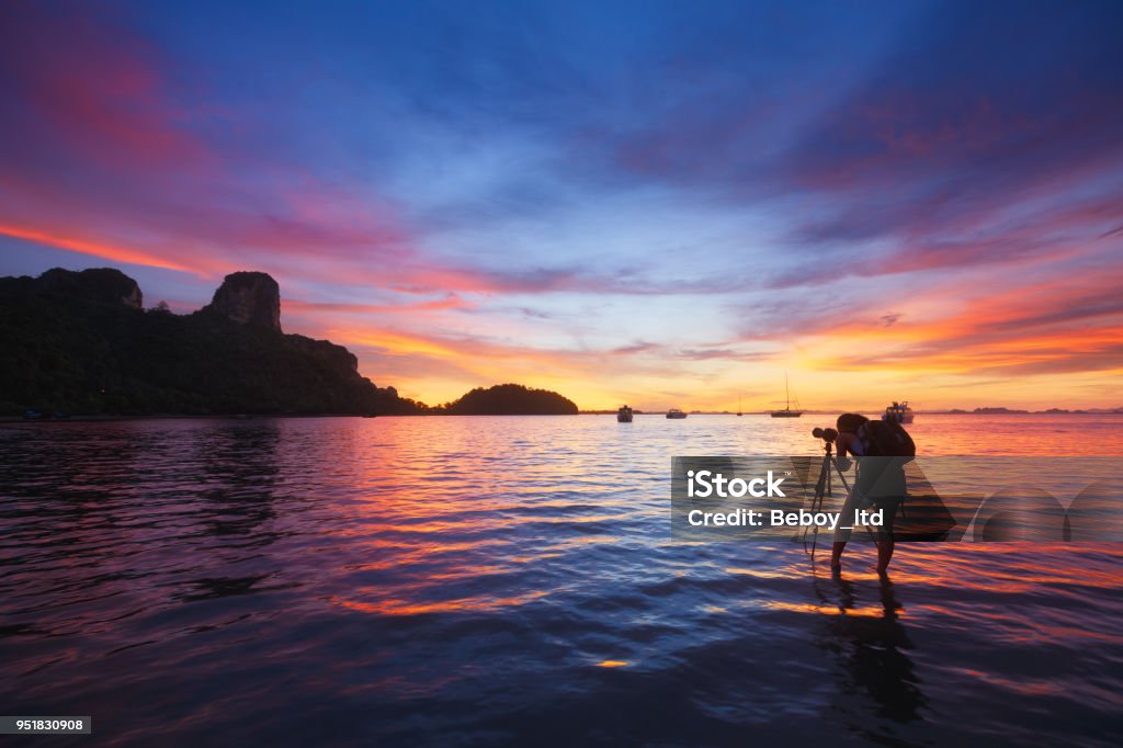 Photographer taking photo of sunrise at East Railay Bay Beach - Krabi, Thailand Photographer Stock Photo