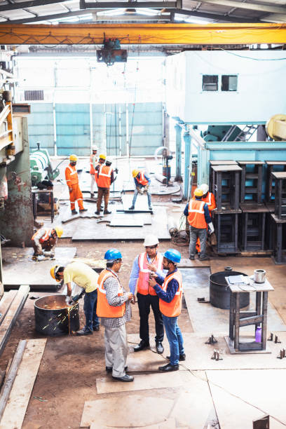 istock Group of supervisors having a discussion while the other employees do their regular tasks. 951832516