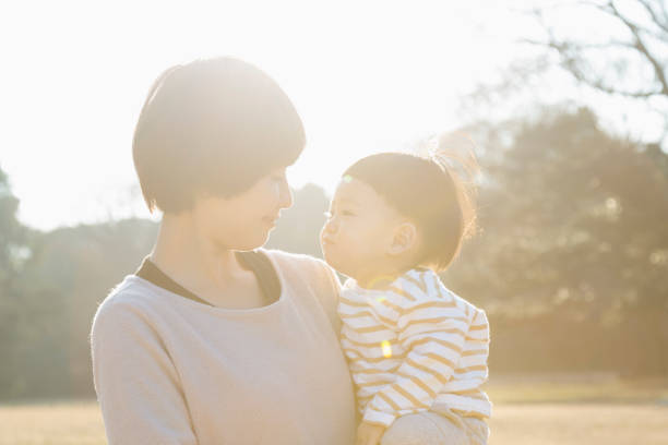 Japanese mother carrying her baby boy and looking each other.