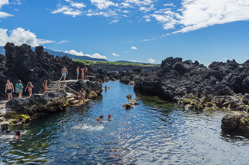 People swimming and enjoying summer in natural lava swimming pools. Biscoitos, Terceira, Azores, Portugal, August 2016