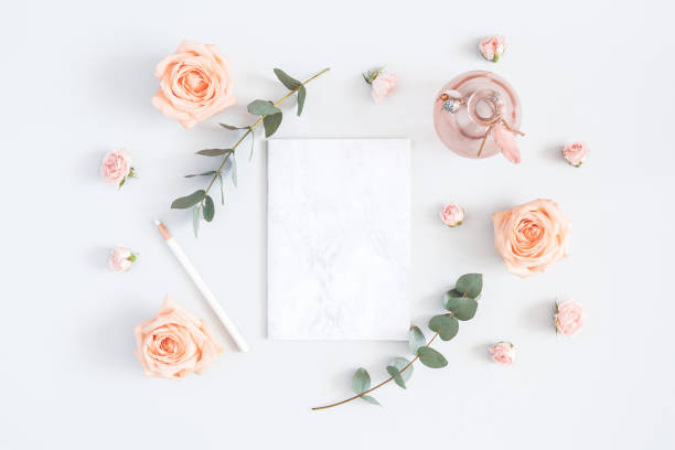 Paper blank, rose flowers, eucalyptus branches. Flat lay, top view