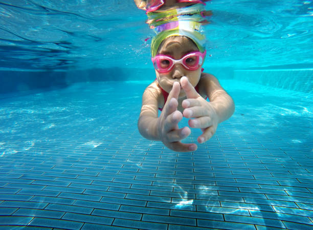 istock happy asian kid swimming underwater in summer. 951847102