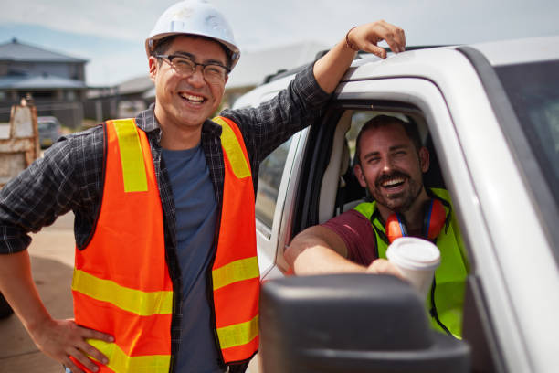 trabalhador sorrindo pelo colega sentado no carro, no site - architect construction engineer standing - fotografias e filmes do acervo