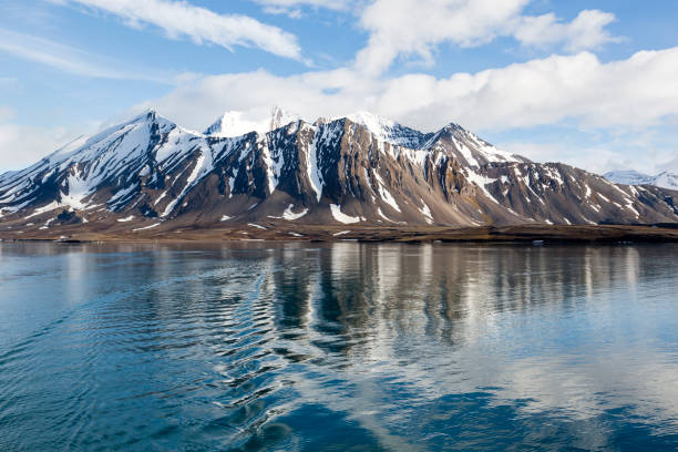 vista desde un barco hacia las montañas nevadas con ondas en el agua en spitsbergen, noruega - svalbard islands fotografías e imágenes de stock