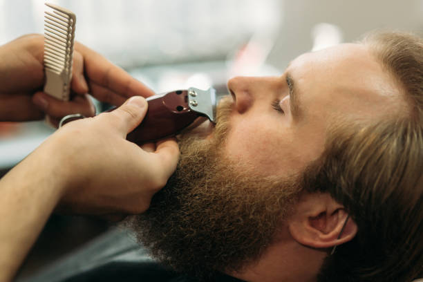istock Bearded man having a haircut with a hair clippers 951851900
