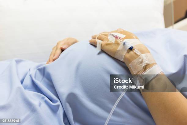 Asian Pregnant Woman Patient Is On Drip Receiving A Saline Solution On Bed Vip Room At Hospital Stock Photo - Download Image Now