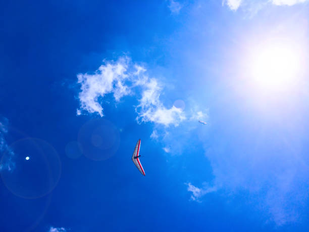 Paraglider and hang-glider on blue sky with clouds background Paraglider and hang-glider in the blue sky with clouds para ascending stock pictures, royalty-free photos & images