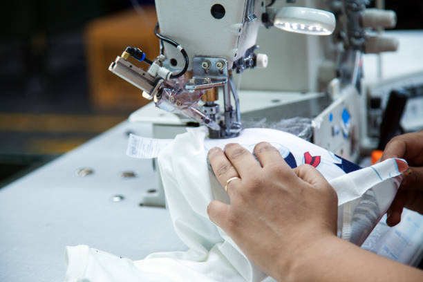 werknemer met behulp van een machine in textielfabriek - uitbeenhandschoen stockfoto's en -beelden