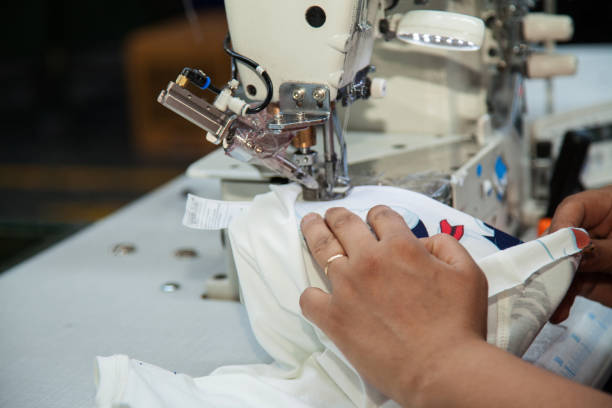 werknemer met behulp van een machine in textielfabriek - uitbeenhandschoen stockfoto's en -beelden