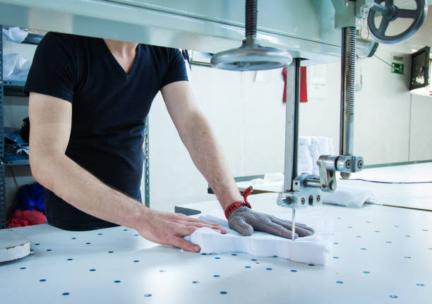 werknemer met behulp van een machine in de fabriek met ijzeren handschoen - uitbeenhandschoen stockfoto's en -beelden