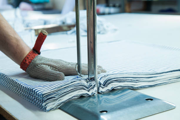 werknemer met behulp van een machine in de fabriek met ijzeren handschoen - uitbeenhandschoen stockfoto's en -beelden