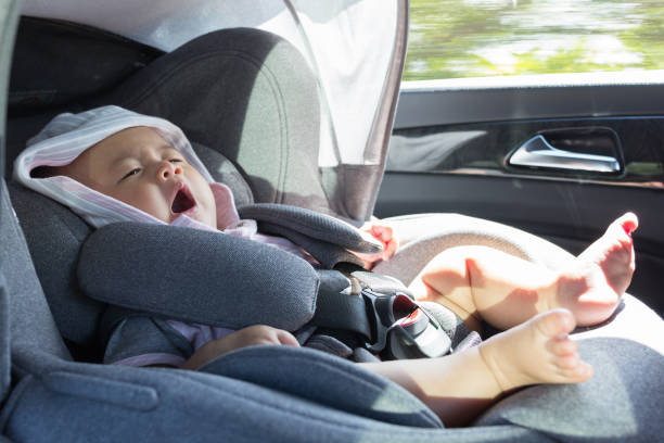 bouchent asiatique mignon bébé nouveau-né assis dans le siège-auto moderne. - baby yawning asian ethnicity newborn photos et images de collection