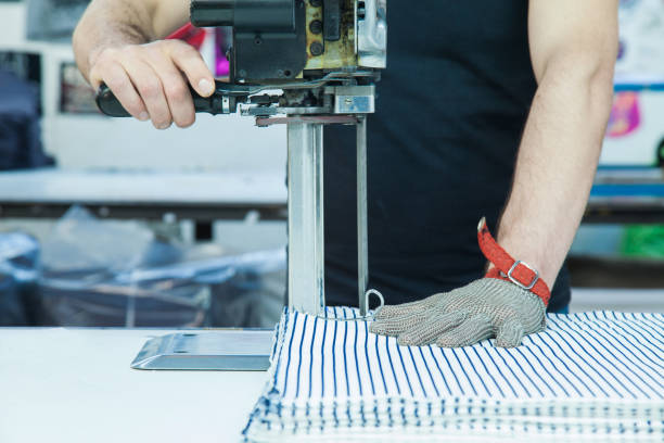 werknemer met behulp van een machine in de fabriek met ijzeren handschoen - uitbeenhandschoen stockfoto's en -beelden