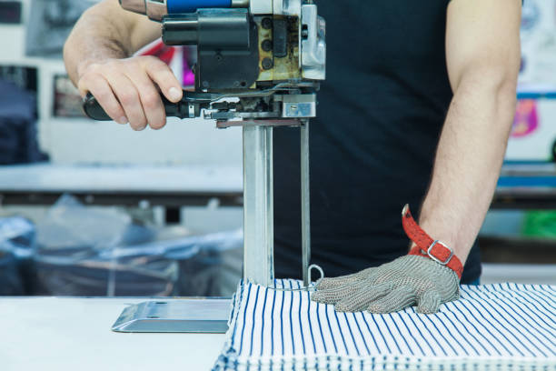 werknemer met behulp van een machine in de fabriek met ijzeren handschoen - uitbeenhandschoen stockfoto's en -beelden