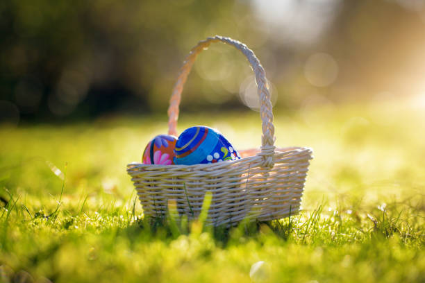 istock Easter basket with traditional painted eggs in the garden or grass. 951869624