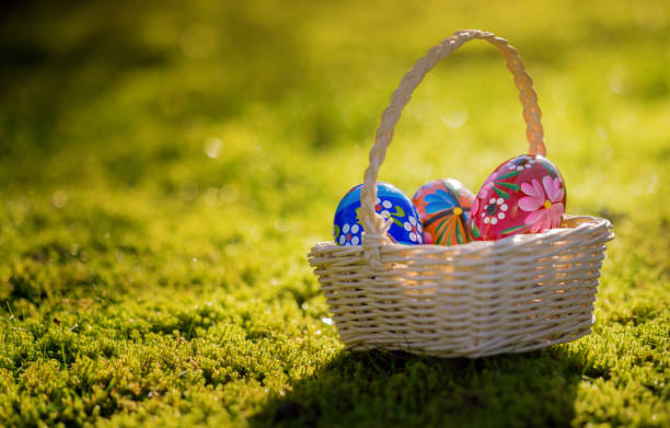 istock Easter basket with traditional painted Easter eggs in green grass 951869674