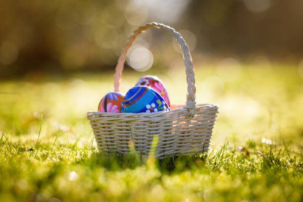 istock Easter basket with traditional painted eggs in the garden or grass. 951869682