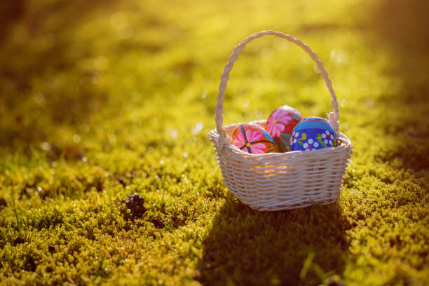 istock Easter basket with traditional painted eggs in the garden or grass. 951869740