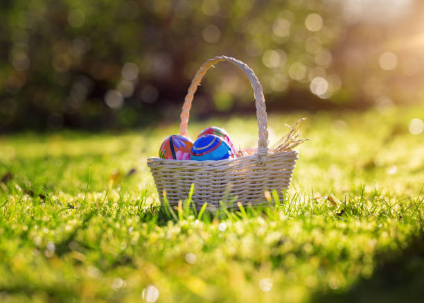 istock Easter basket with traditional painted eggs in the garden or grass. 951869770
