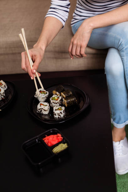 istock Woman eating sushi at home. 951876134