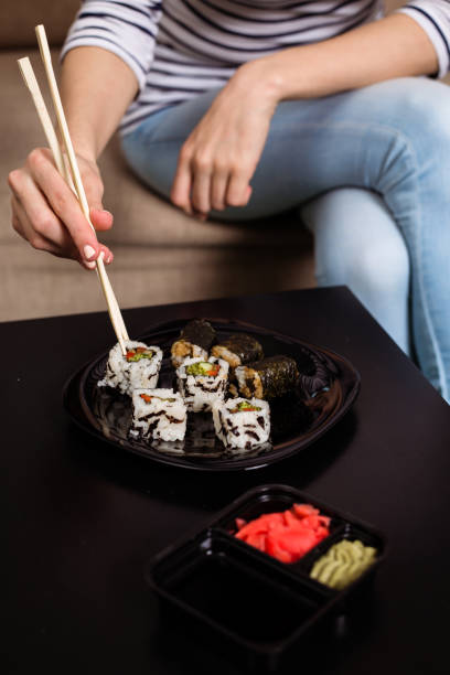 istock Woman eating sushi at home. 951876140
