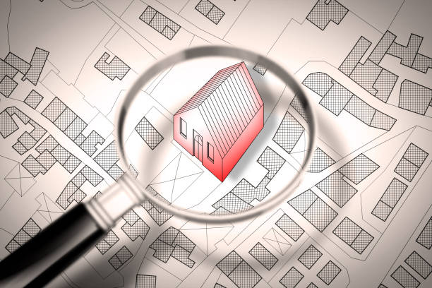 istock Searching new home concept image - Imaginary cadastral map of territory with buildings and roads through magnifying glass 951876186