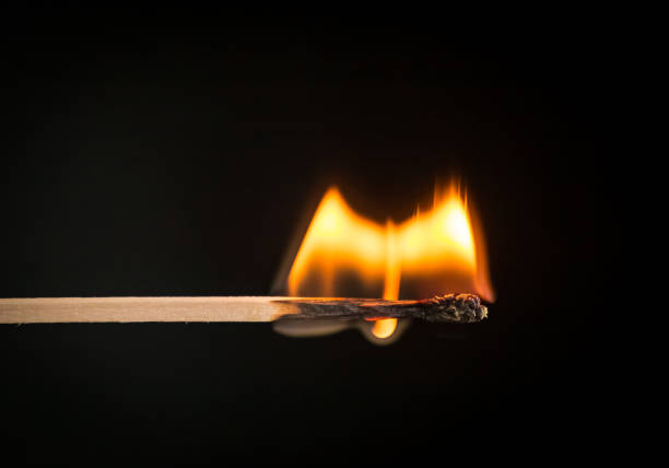 A selective focus of a match on fire on black background